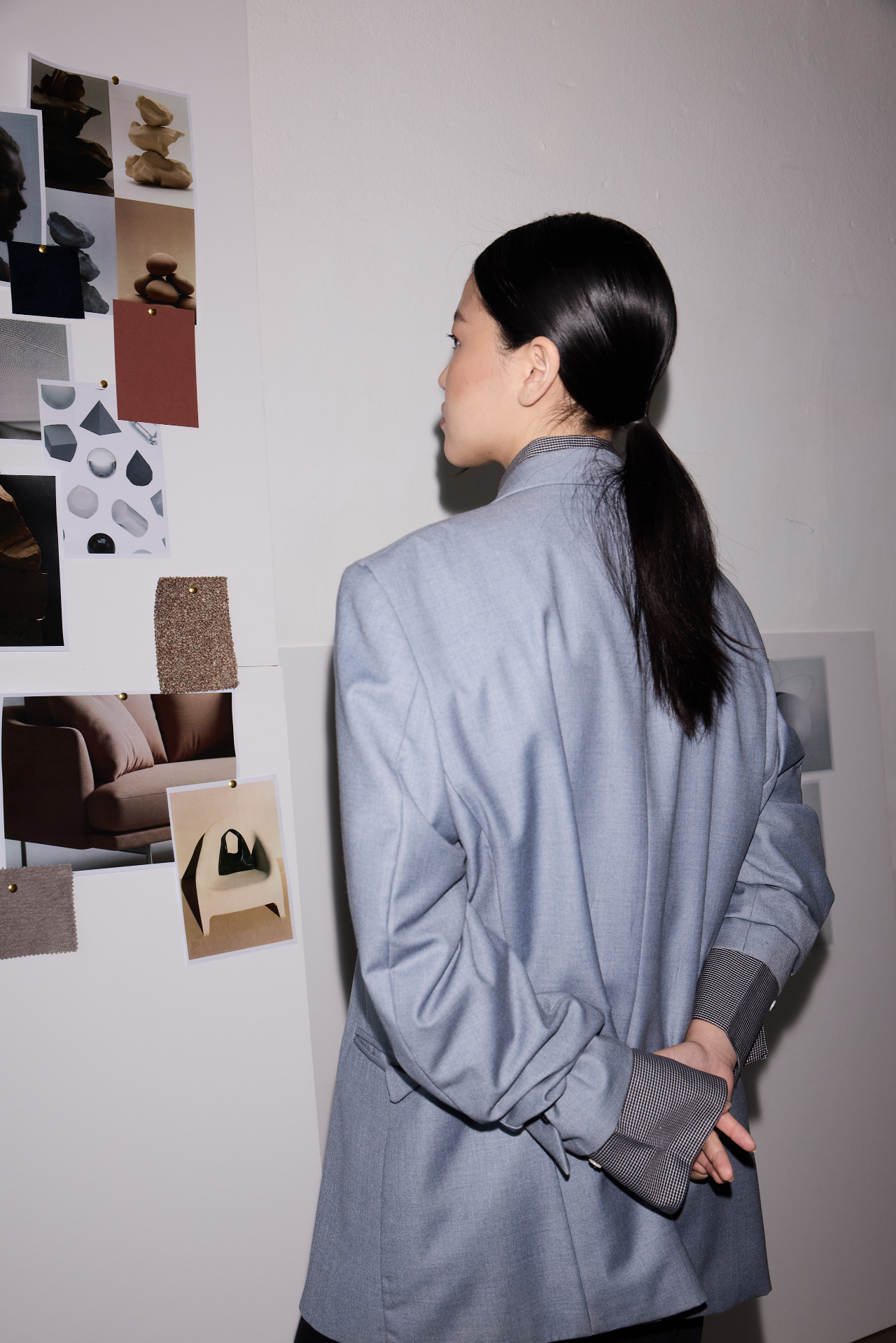 A professional reviewing materials pinned to a studio wall